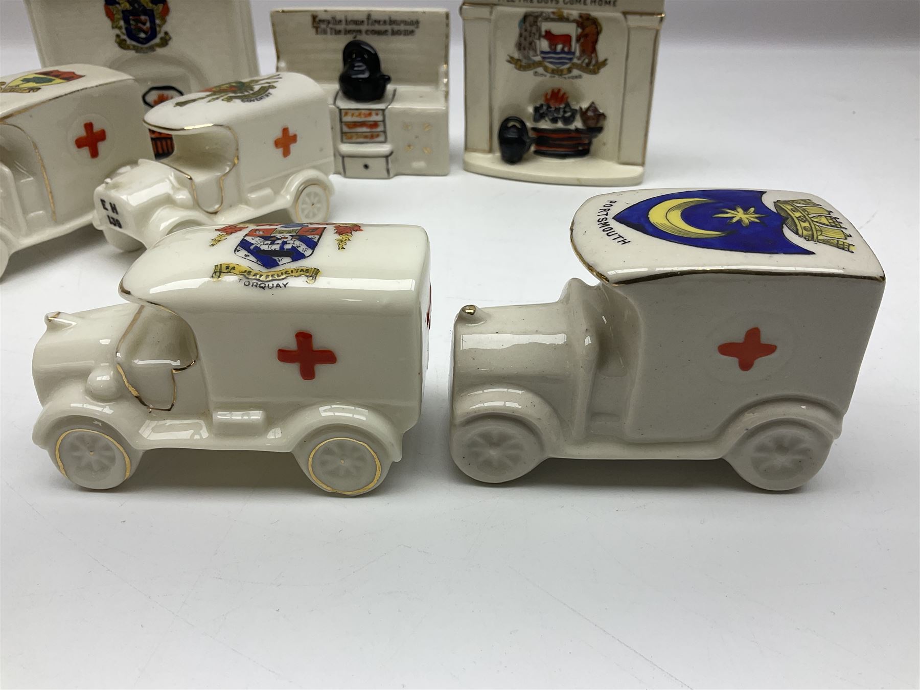 Ten WW1 crested china military models comprising seven field ambulances and three 'Home Fires Burning' fire-surrounds/range; various makers including Willow Art, Arcadian China, Grafton China, Savoy China, Carlton China etc; various crests including Devon, Aldershot, Portsmouth, West Ham, Coventry, Oxford, Hastings, Brighton etc (10)