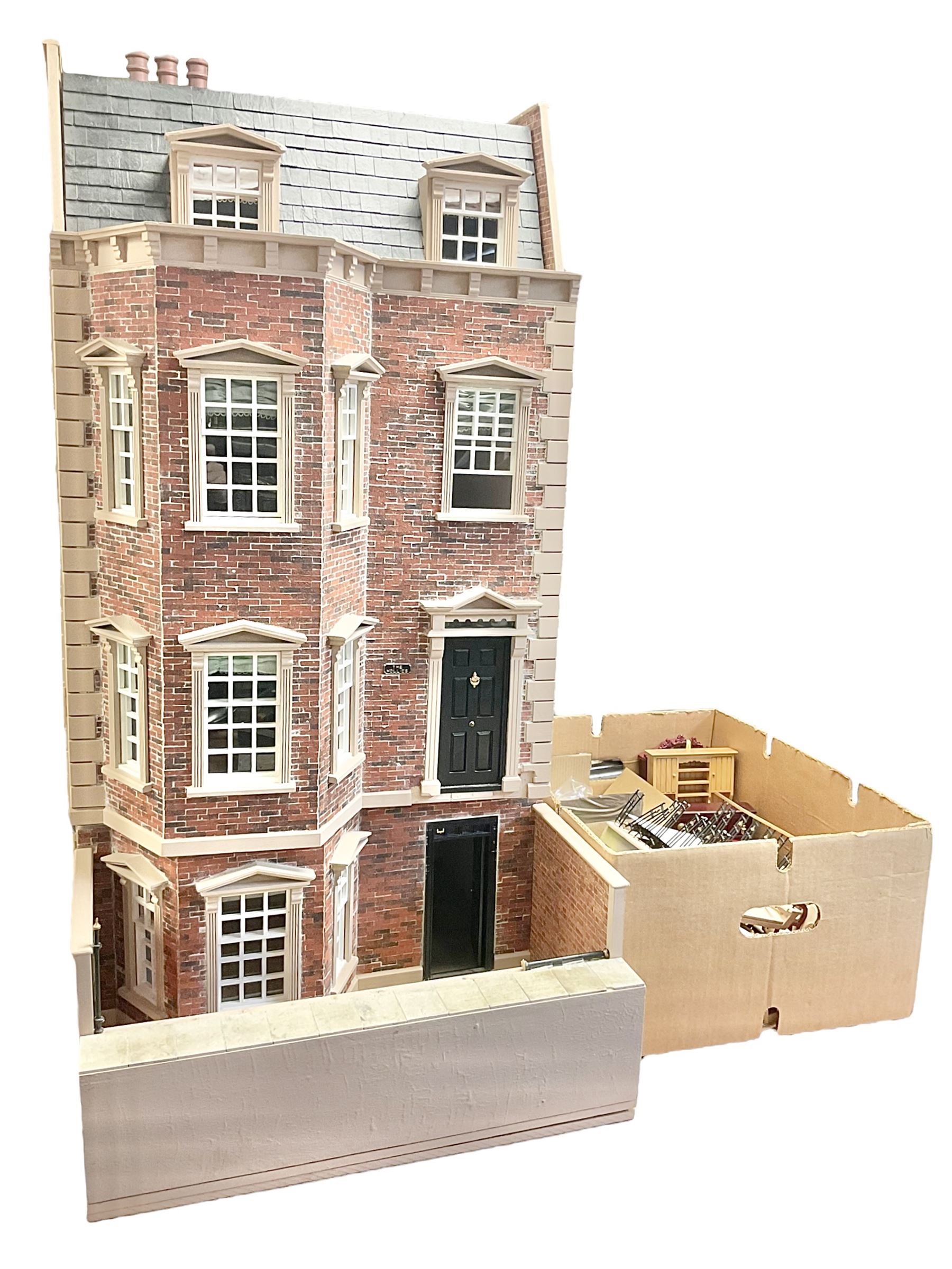 'The Hollies' - good quality sectional wooden doll's house in the form of a Georgian style four-storey bay windowed town house with simulated brick front elevation, rendered sides, off-set corner stonework, faux slate-hung top floor with flat roof and chimney stack, working sash windows, iron railings around front basement courtyard with hinged front elevation to two rooms with  spiral staircase, side hinged central section approached by external steps with iron balustrades to the sides leading to a front door, entrance hall with stairs to landing and two rooms on two floors with dado panelling and fire-surrounds, the top floor with top hung front elevation revealing stairs to a landing and bedroom; wired for electricity L51cm D65cm H107cm including chimney; together with a good quantity of quality wooden furniture and accessories including piano, dressers, bookcase and books, rugs, double half-tester bed, metalware, pictures etc