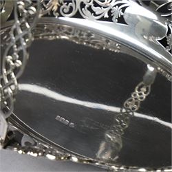 Early 20th century swing handled basket, of oval form with pierced sides and floral C scroll rim, upon four bun feet, hallmarked William Hutton & Sons Ltd, Sheffield 1915, widest point W29cm