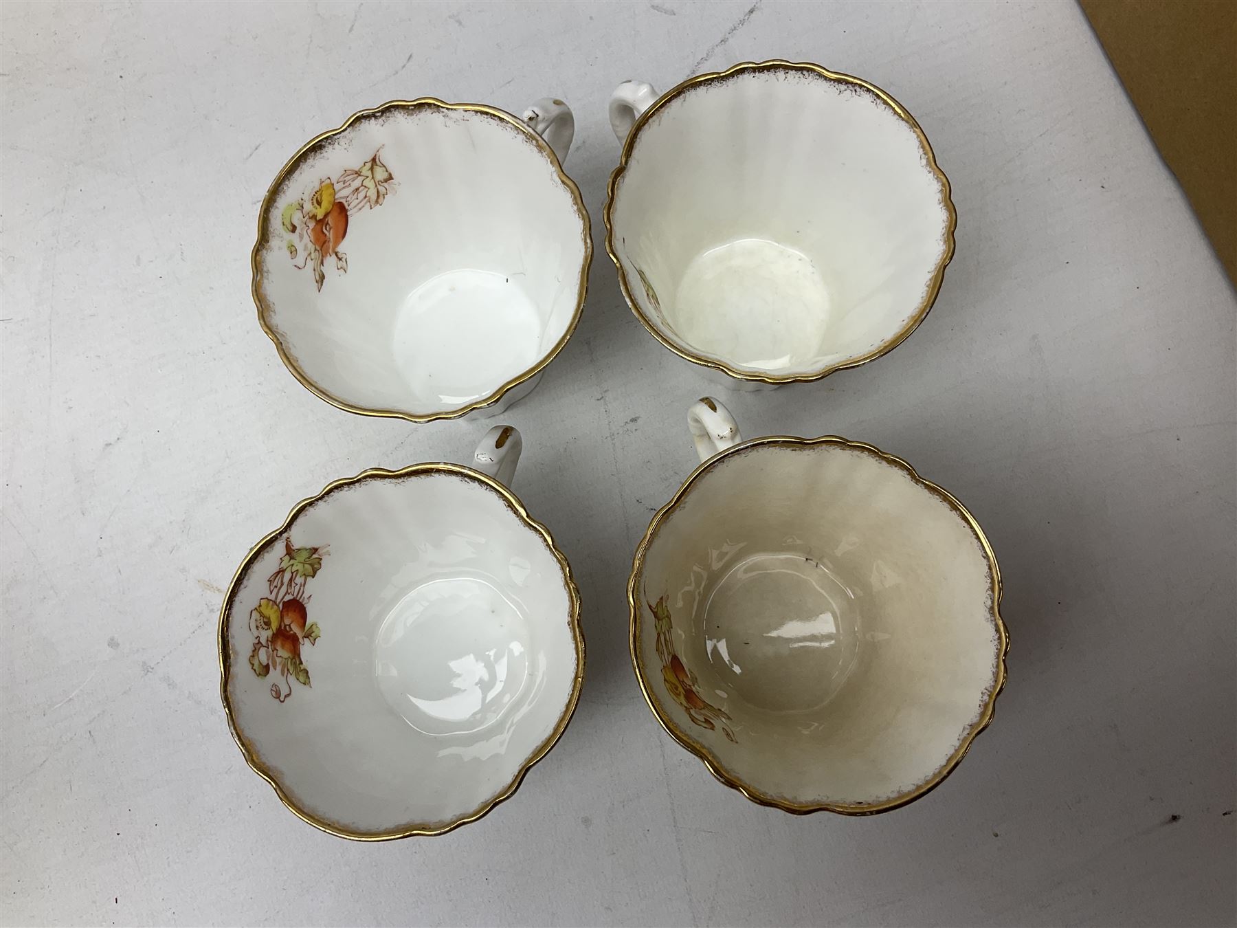 Quantity of Royal Albert tea wares to include 'Moss Rose' teapot, sucrier and saucers, together with teacups, saucers, side plates, jug etc decorated with orange, yellow and blue floral sprays with gilding upon plain ground, all stamped Royal Albert beneath