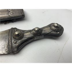 Late 19th/20th century Middle Eastern jambiya dagger the 36cm broad curved double edged steel blade with traces of script, horn and copper backed waisted white metal hilt with three roundel buttons; in ornate white metal and leather mounted brass and steel scabbard L60.5cm overall