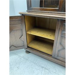 Waring and Gillow - oak bookcase on cupboard, projecting cornice over arcade frieze, guilloche upright decoration, the top section enclosed by three astragal glazed doors, the lower section enclosed by three geometric panelled doors with blind fretwork decoration, on turned feet