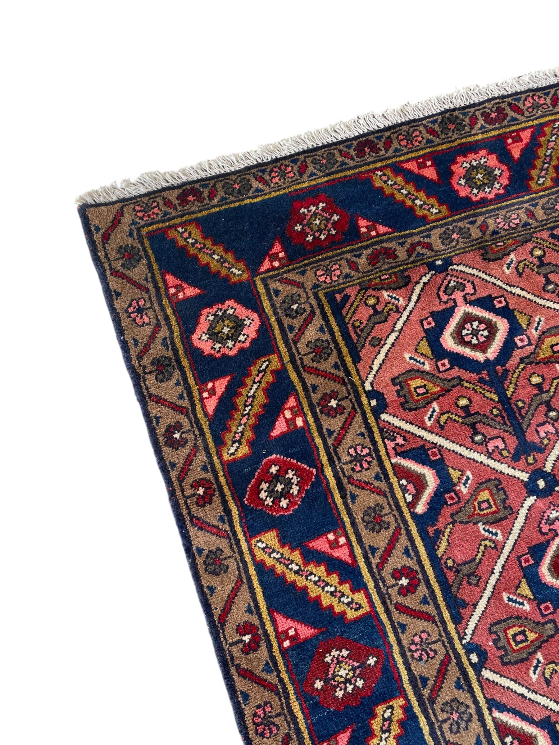 Persian Ardakan crimson ground rug, the field divided by lattice and decorated with stylised tree of life motifs, the border decorated with geometric flower heads, within guard stripes 