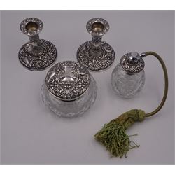 Four piece silver mounted dressing table set, comprising pair of candlesticks, cut glass jar and cover, and perfume atomiser, each repousse decorated with birds amidst foliate motifs and scrolls, hallmarked W I Broadway & Co, Birmingham 1966 and 1968,candlesticks H9.5cm