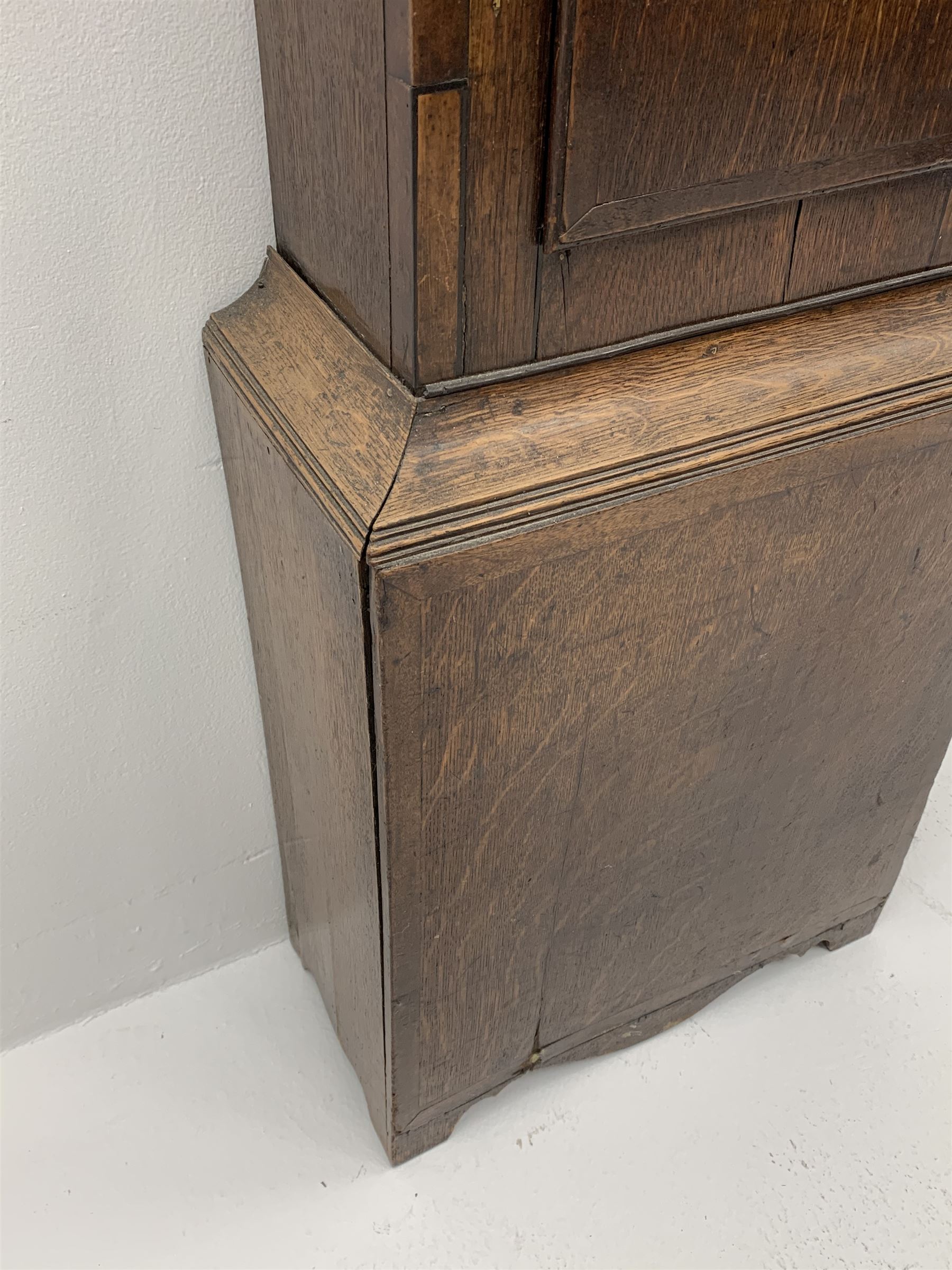 Early 19th century oak longcase clock, shaped pediment over a stepped arch glazed door enclosed by plain pilasters, the case with canted corners and trunk door with sloped arch top and centre curved return, enamel Arabic dial painted with flowers and patterned spandrels, signed 'Jno. Hilbert, Haxby', eight-day movement with subsidiary seconds dial and false calendar dial 