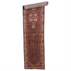 North-west Persian Malayer runner rug, the indigo ground decorated with ivory medallions and an all-over Herati pattern, red floral spandrels, enclosed by an ivory trailing floral border and crimson patterned guard stripes