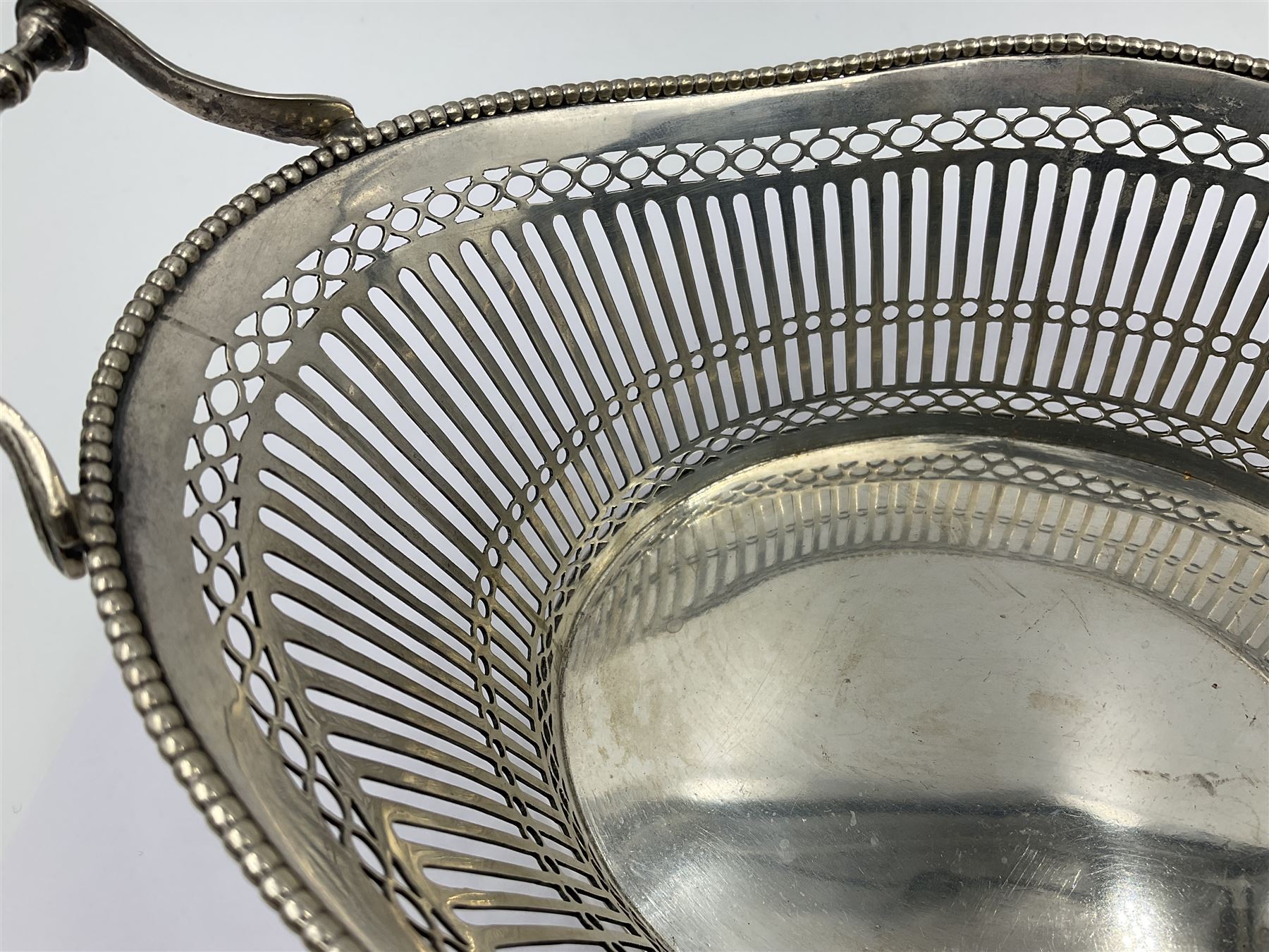 Early 20th century Dutch silver basket, of oval form with pierced sides, beaded rim, and twin handles, marked with Lion Passant for 2nd standard purity and date letter for 1910, other marks worn and indistinct, including handles H8.5cm L25.5cm
