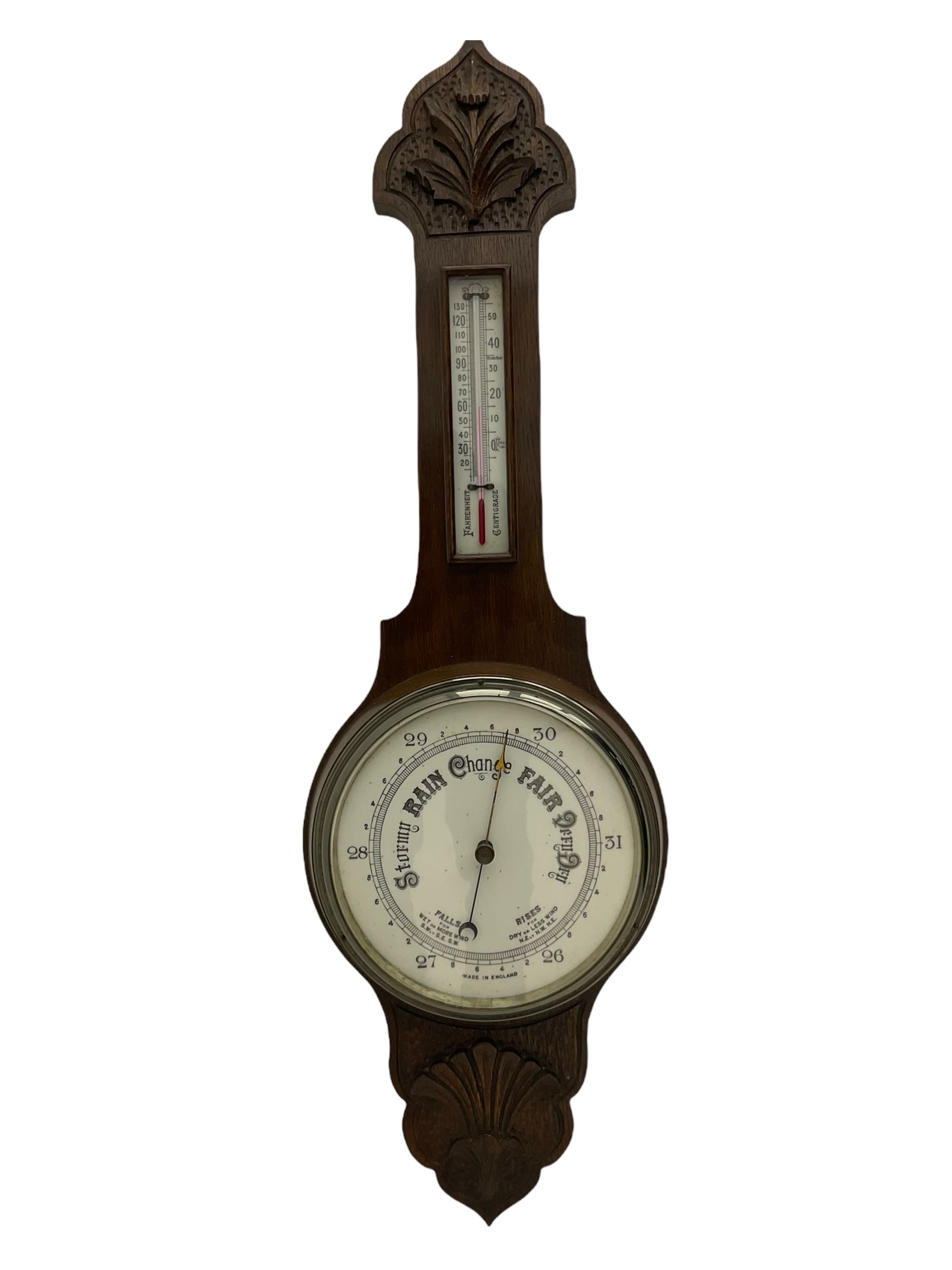 An English carved oak cased aneroid barometer with an 8'' porcelain