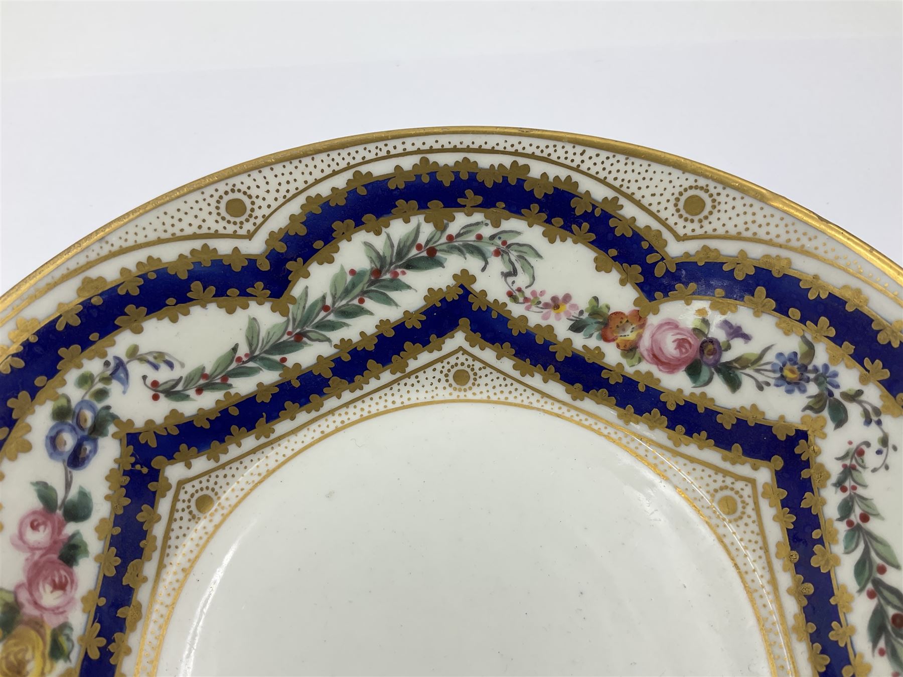 Sèvres soft paste porcelain coffee can and saucer with date code for 1767, painted with floral and laurel leaf garlands within blue scalloped and gilt borders, interlaced LL monogram enclosing the date letter O above painters mark for Catrice, coffee can H7.5cm, saucer D15cm