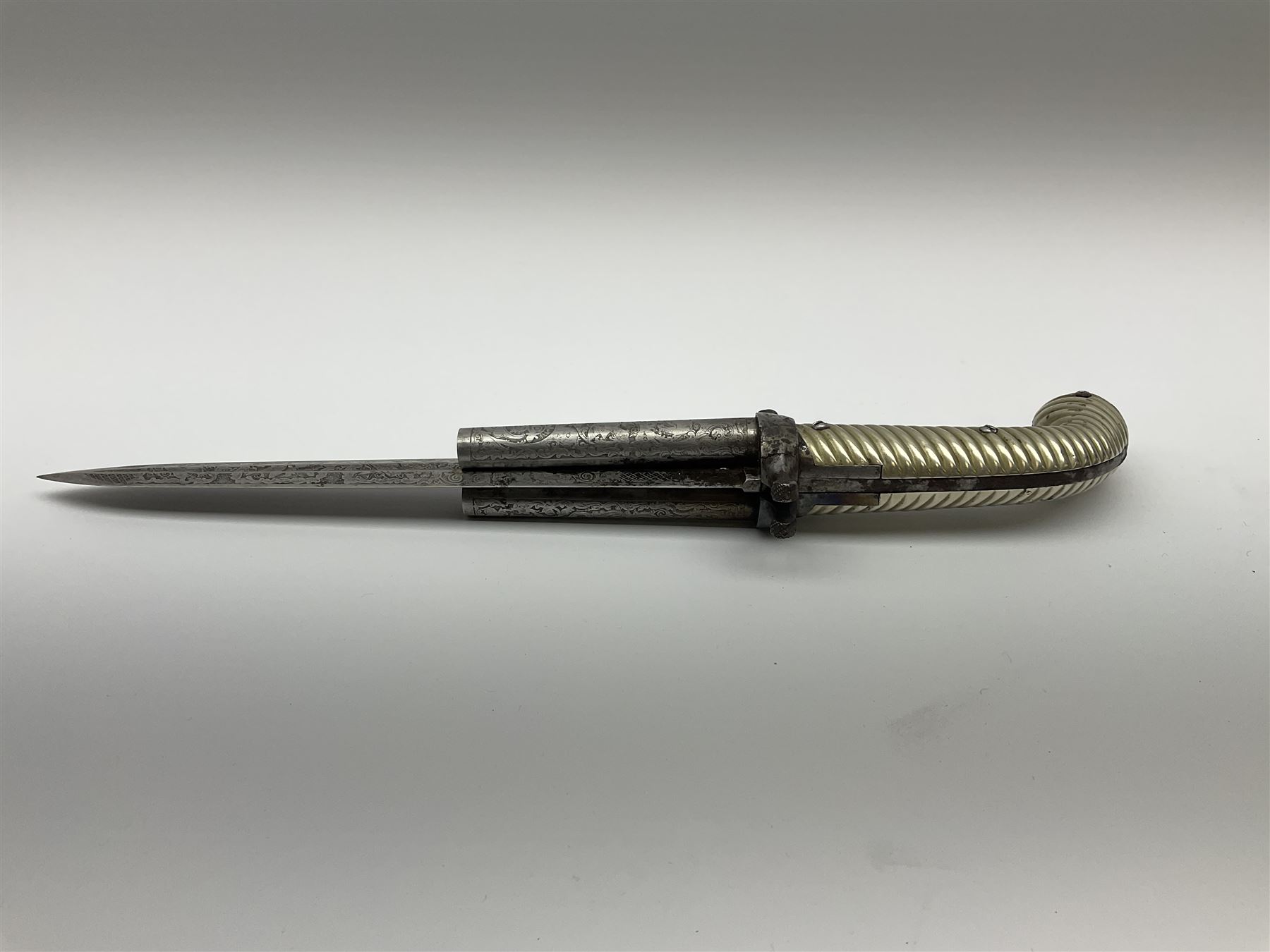 Rare double barrel percussion knife pistol by Dumonthier & Sons (NVN), approx. .38 calibre, with 8.5cm barrels and central 21.5cm spear pointed blade, all with etched damascening, upper quillons serve as hammers for the percussion ignition with single drop down trigger and fluted nickel grips, in nickel mounted leather covered tin scabbard L33.5cm overall