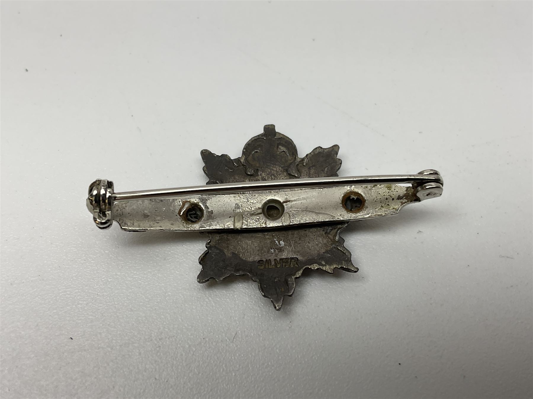 Popski's Private Army sterling silver cap badge; and two silver sweetheart brooches for Highland Light Infantry as a rifle and silver gilt Glengarry badge and Army Service Corps with blue enamel; and another silver badge (4)