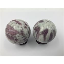 Pair of pink tourmaline spheres, upon carved wooden bases, D5cm