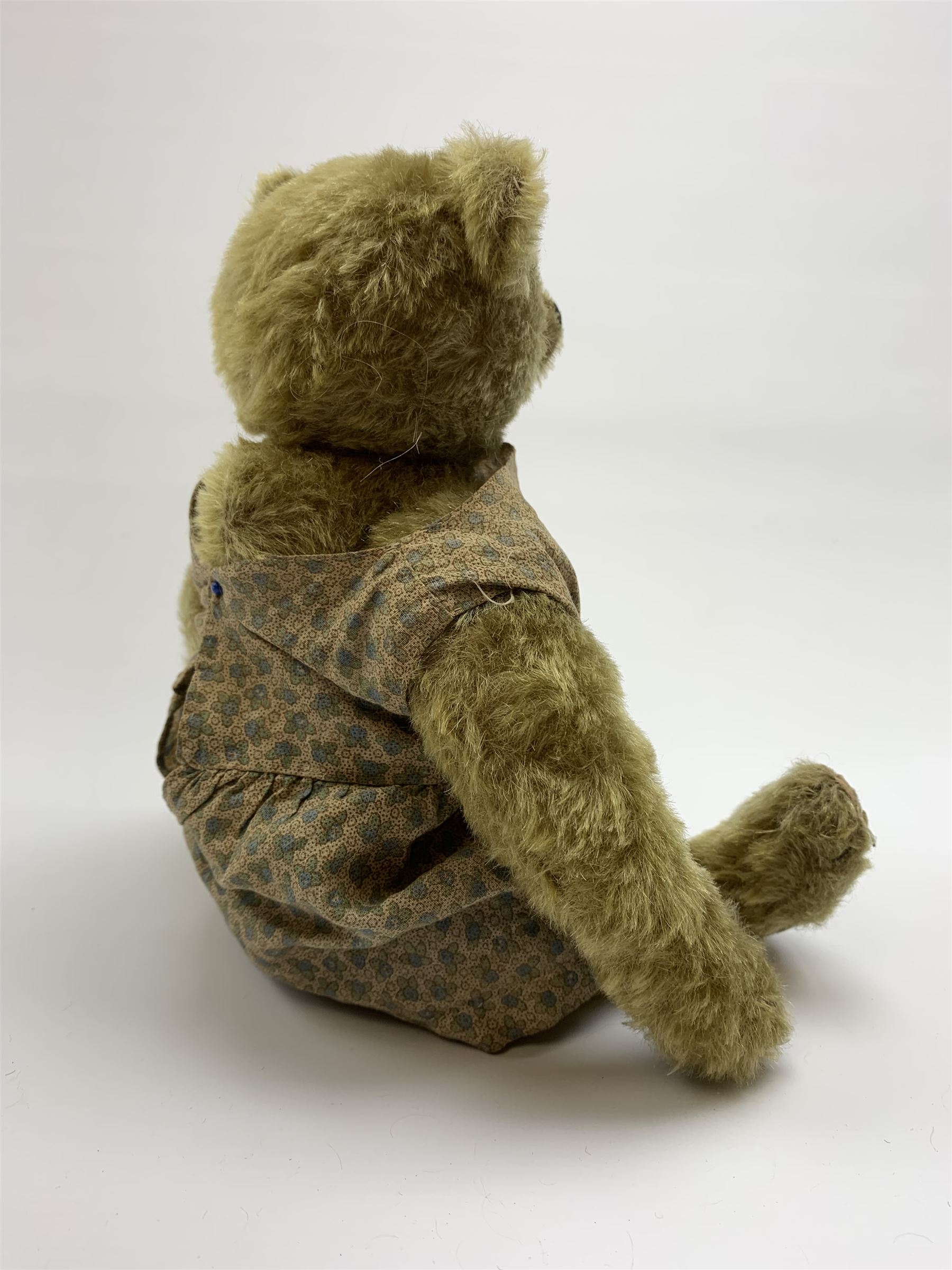 Early 20th century German Steiff teddy bear c1910 with wood wool filled humped back mohair body, swivel jointed head with black boot button eyes and horizontally stitched black nose and mouth, FF metal button to left ear, jointed elongated limbs with felt paw pads and black stitched claws H13