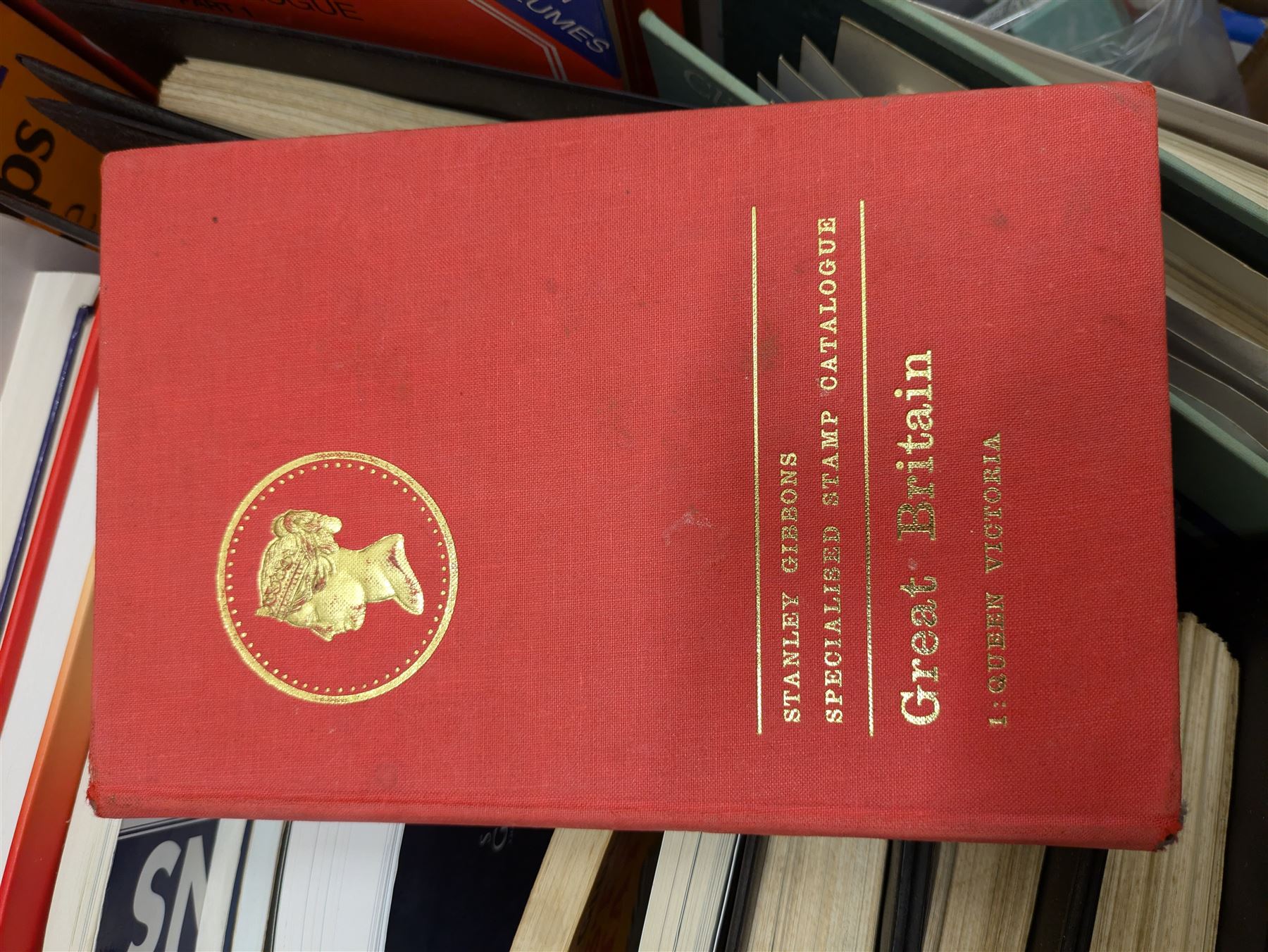 Stamp and coin reference materials, including Stanley Gibbons 2023 'Great Britain Concise' stamp catalogue, various editions of 'The Postal Stationary Society', empty stamp albums etc, in two boxes