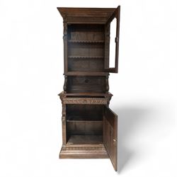 French carved oak cabinet in the Renaissance revival style, cornice carved with scrolling acanthus flanked by lion mask ring terminals, above glazed door with scroll supports over a carved panelled cupboard section with radiating shell motif and geometric quarter panels with foliate ornamentation, raised on a moulded plinth base 