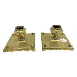 Pair of brass candlesticks, the square bases with beaded edge supporting shaped sockets 