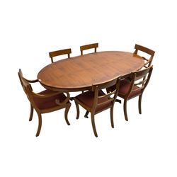 Regency design yew wood dining table, oval cross-banded top with reeded edge, raised on turned pedestal with reeded sabre supports terminating in brass hairy paw feet and castors (W138cm D100cm H75cm); and Rackstraw - set six (4+2) Regency design dining chairs with red drop-in seats (W50cm H86cm)