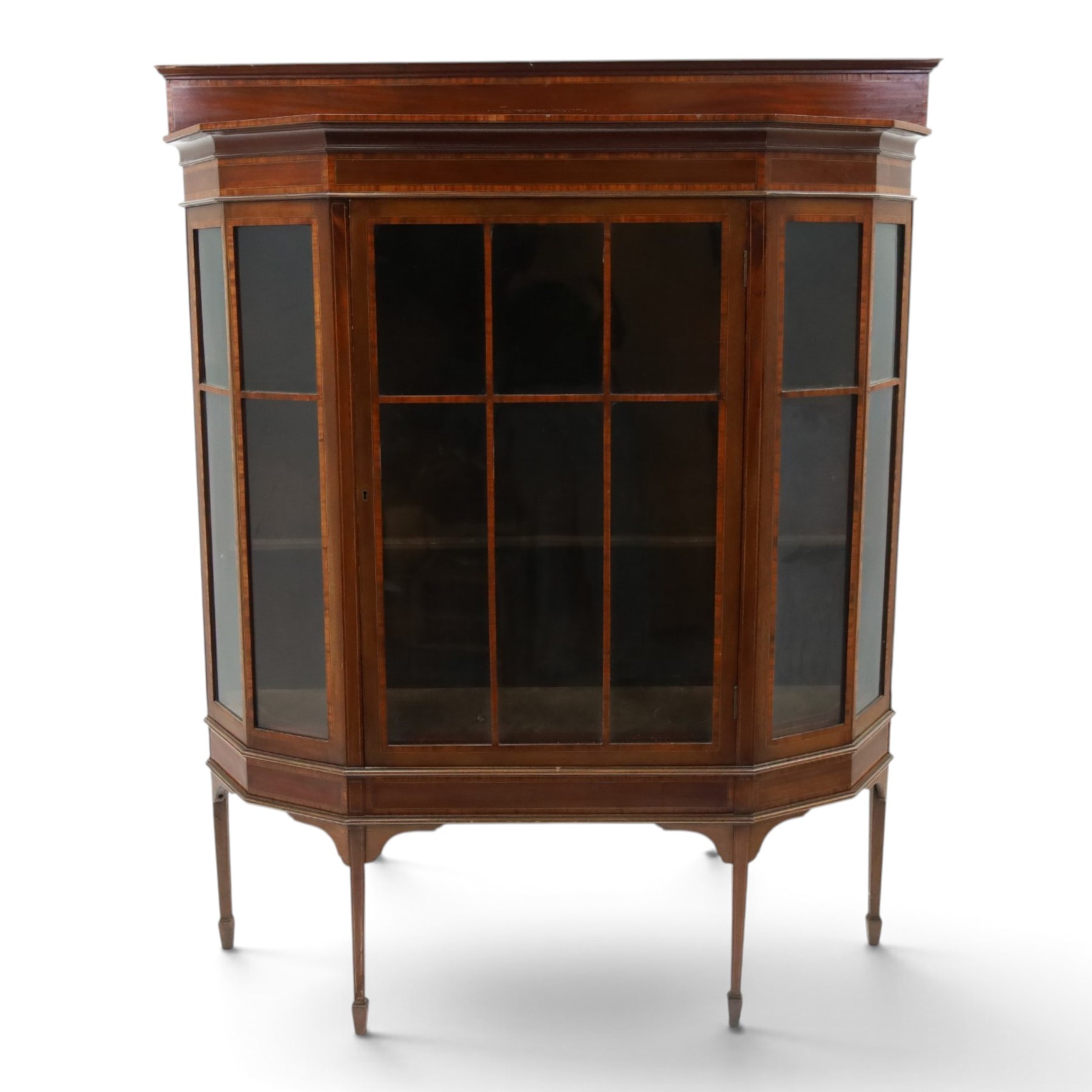 Edwardian inlaid mahogany display cabinet of rectangular canted form, galleried top with crossbanded inlay, above a glazed cabinet enclosing  baize lined shelves, raised on square tapering legs terminating in spade feet  