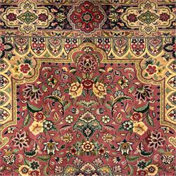 Kashan design hand knotted wool carpet, decorated with an ivory and green floral medallion on a pink ground with scrolling vines, ivory spandrels, multiple navy and ivory borders with stylised flowerheads, from the region of Punjab, Pakistan