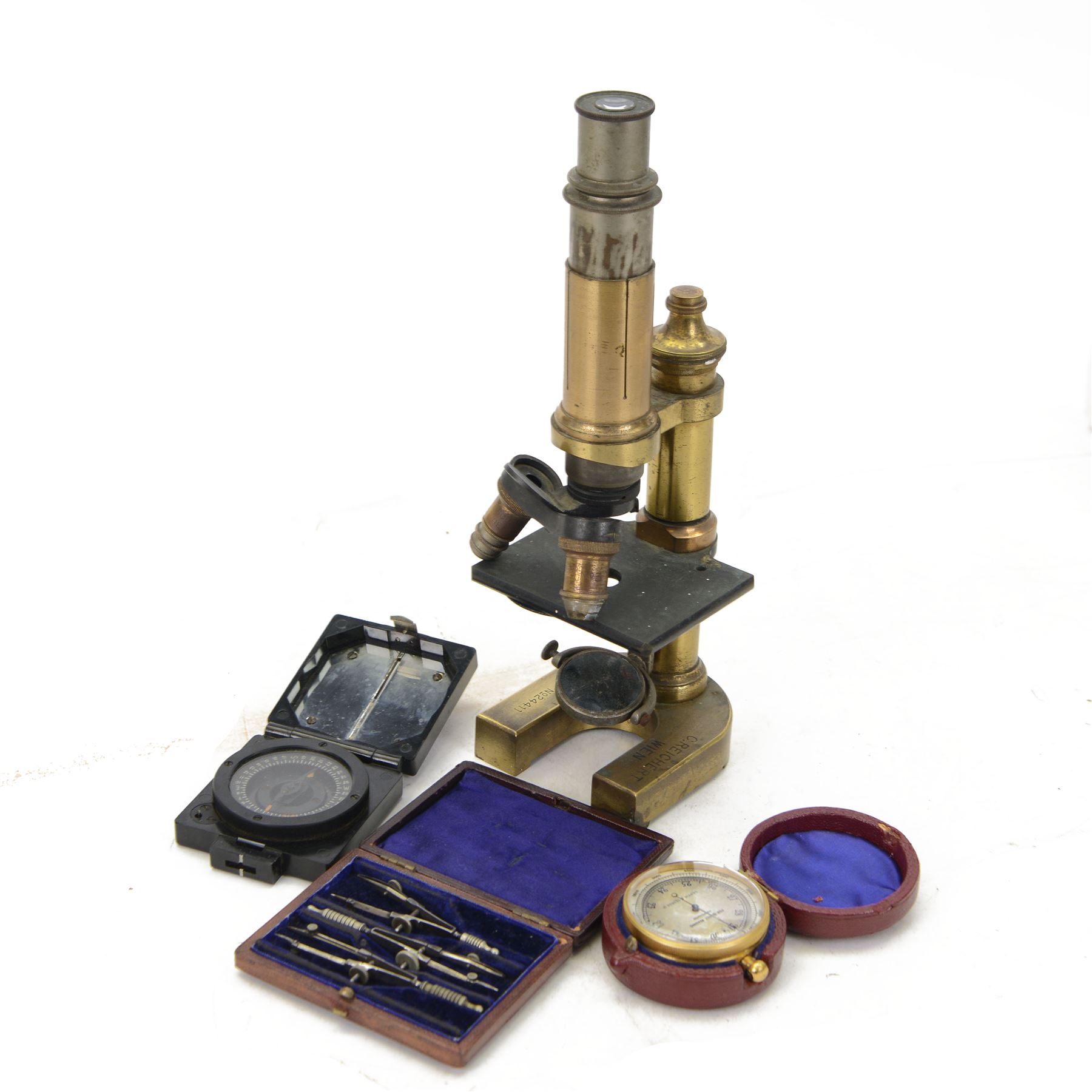 Early 20th century Austrian brass monocular microscope by C Reichert, together with a brass cased pocket barometer by Griffin & George, a WWII TG Co Ltd Mark 1 Magnetic Marching Compass and a drawing set