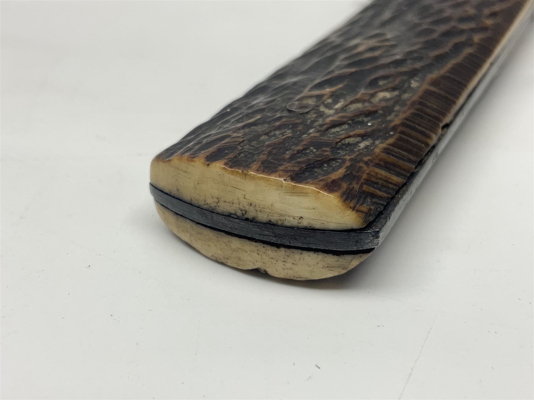 WW2 fighting knife, the 13cm blade by Priestman of Sheffield marked with scout and camp fire motif; two piece antler grip; in leather sheath crudely marked R.T. with a broad arrow L23cm overall Auctioneers Note: By family descent this knife was reputedly presented to Richard Towse during WW2 for guarding a group of POWs.