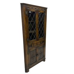 Jacobean design oak corner display cabinet, lunette carved frieze over lead glazed doors, fitted with drawer and double cupboard below