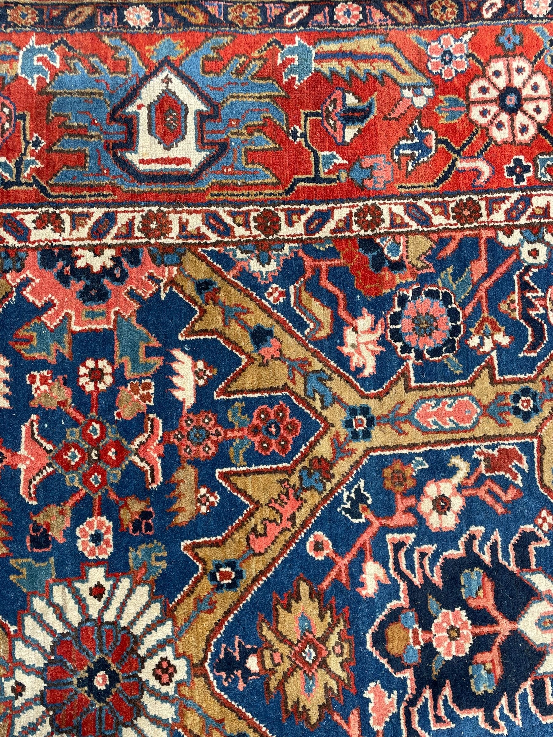 Persian blue ground carpet, the field divided up into panels by trailing bands with flower heads, each panel decorated with palmettes and stylised plant motifs, the border decorated with further palmettes, within floral pattern guard stripes 