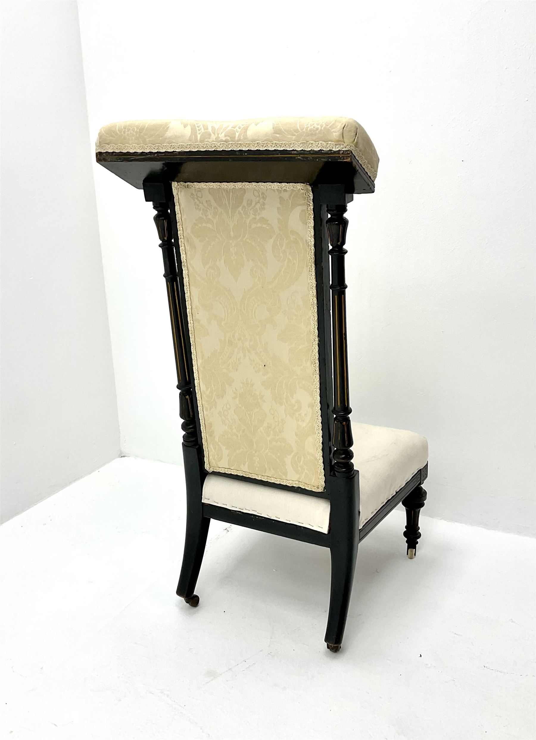 Victorian ebonised prie dieu chair upholstered in an ivory ground fabric, turned reeded and tapering supports