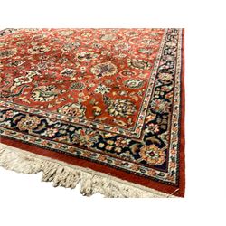 Persian Qual red ground carpet, the field decorated with all-over scrolling palmette decoration and foliate patterns, the guarded border with repeating stylised plant motifs