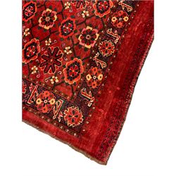 Persian red ground rug, the field decorated with lattice pattern and flowerhead, repeating border decorated with flower heads and leaf motifs