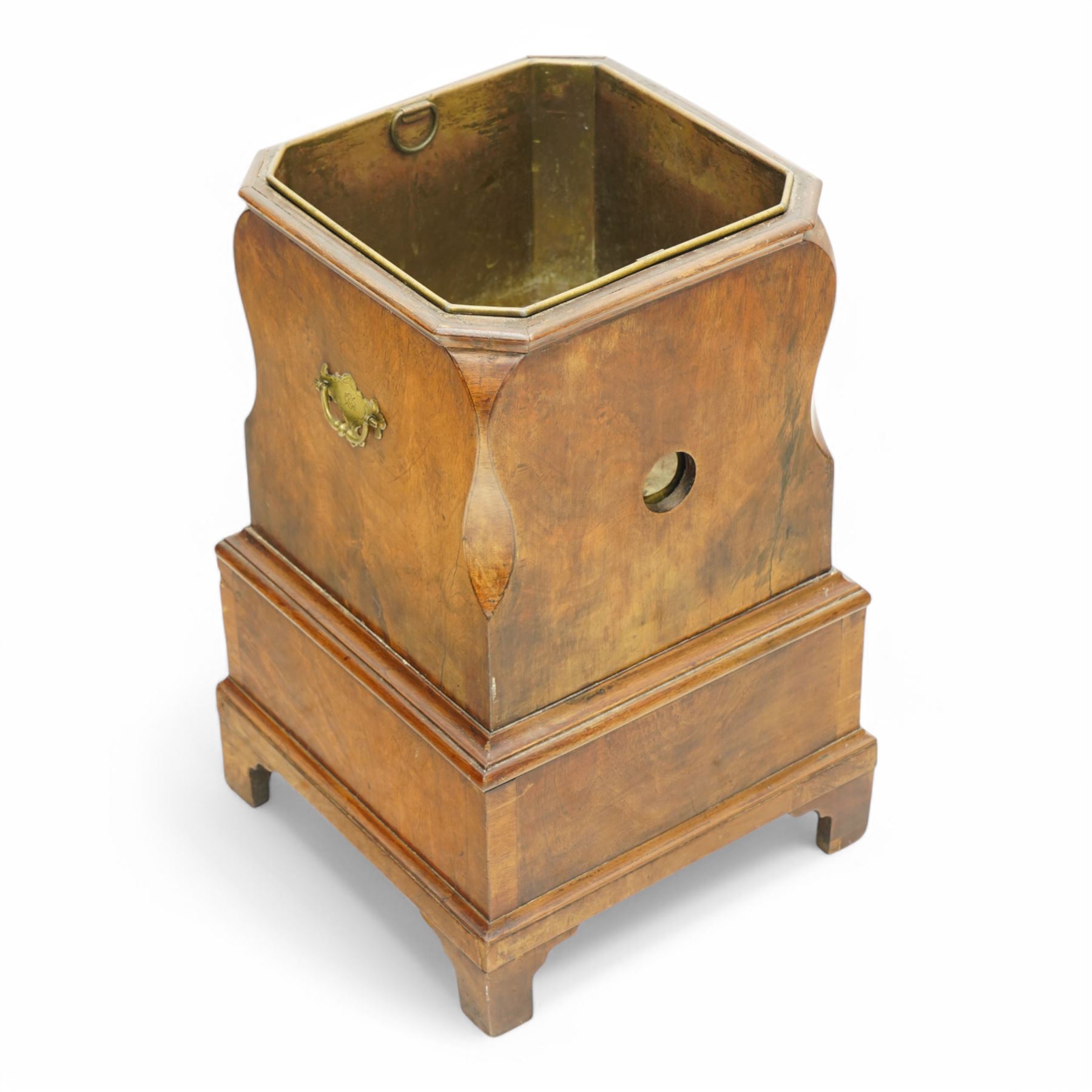 George III figured walnut champagne or wine cooler, of stepped square form with ogee cut-outs, fitted with two drawers, shaped handle plates with engraved decorated to each side, with brass liner, on bracket feet 
