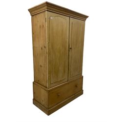 Victorian waxed pine double wardrobe, moulded cornice, enclosed by two doors with applied raised pointed panels, drawer to base on skirt