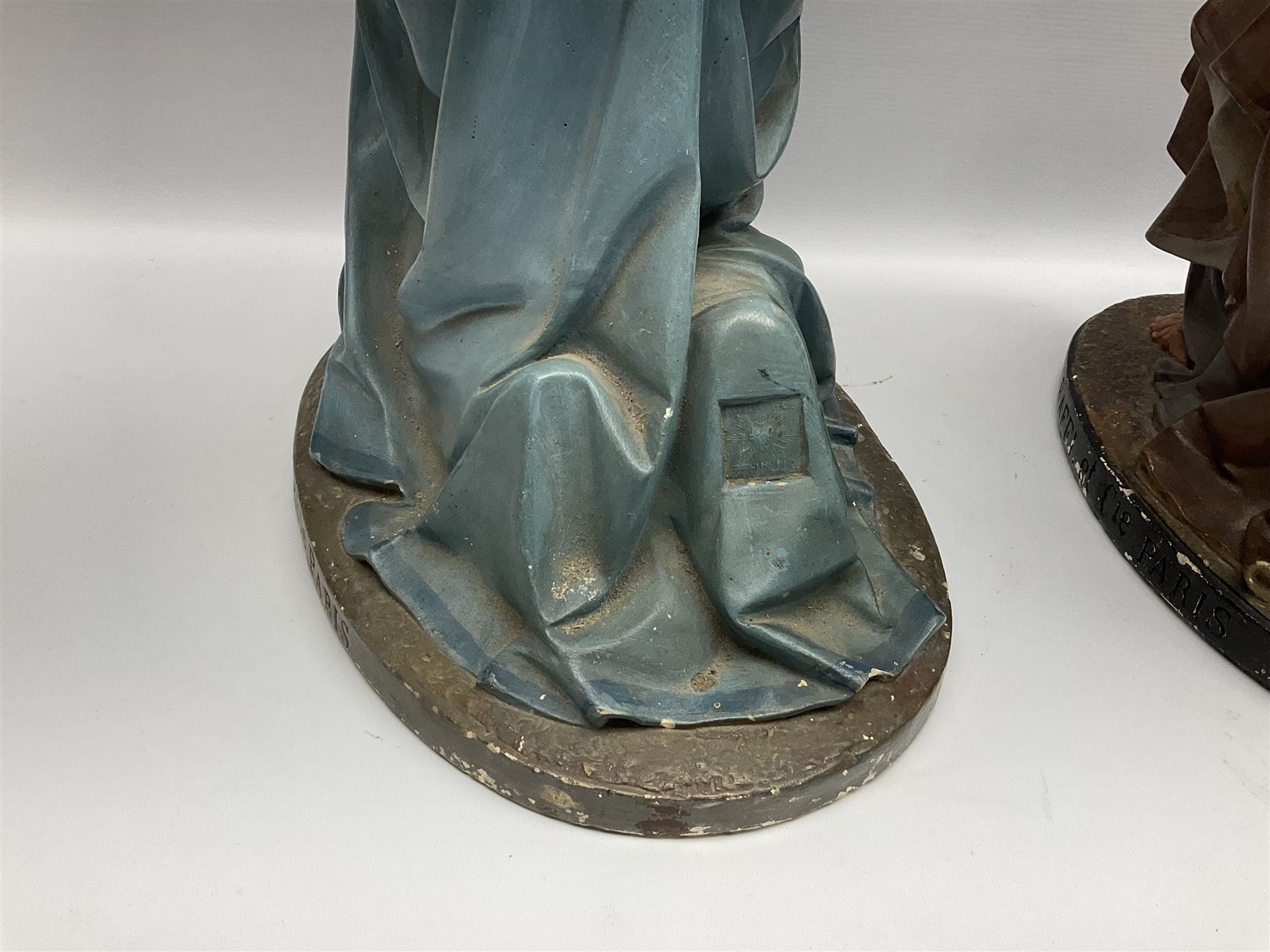 Two religious painted plaster figures of Mary and Joseph kneeling on oval plinths, with impressed mark 'Raffl et Cie Paris', H60cm 
