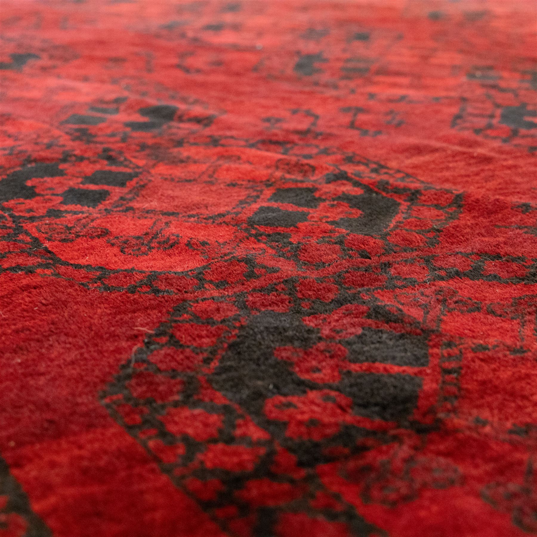 Turkmen Bokhara carpet, with a deep red field and repeating rows of black gul motifs, within multiple geometric borders