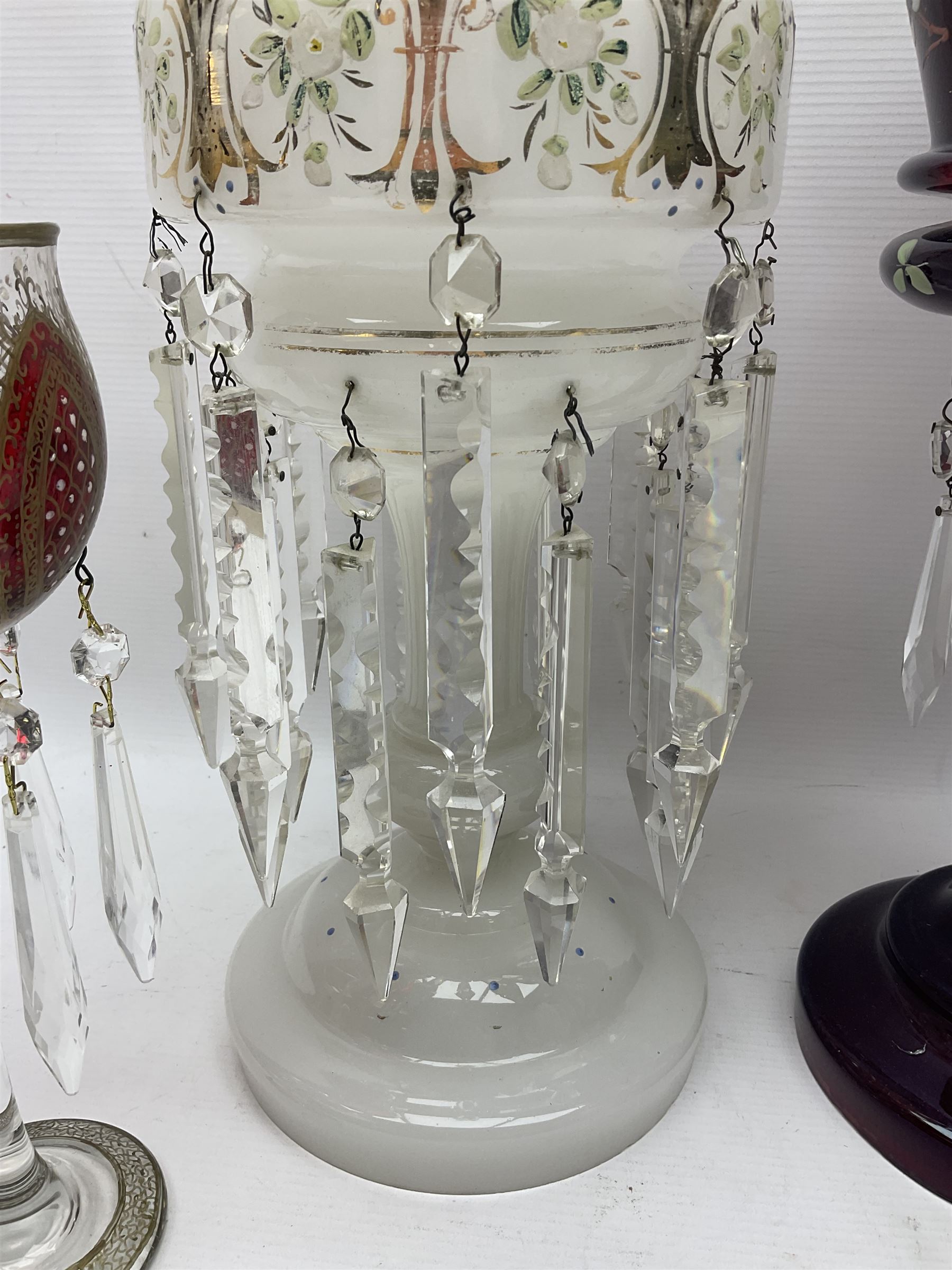 Bohemian red glass lustre, painted with stylised floral and foliate decoration, together with a milk glass example and two bohemian goblets converted to lustres 