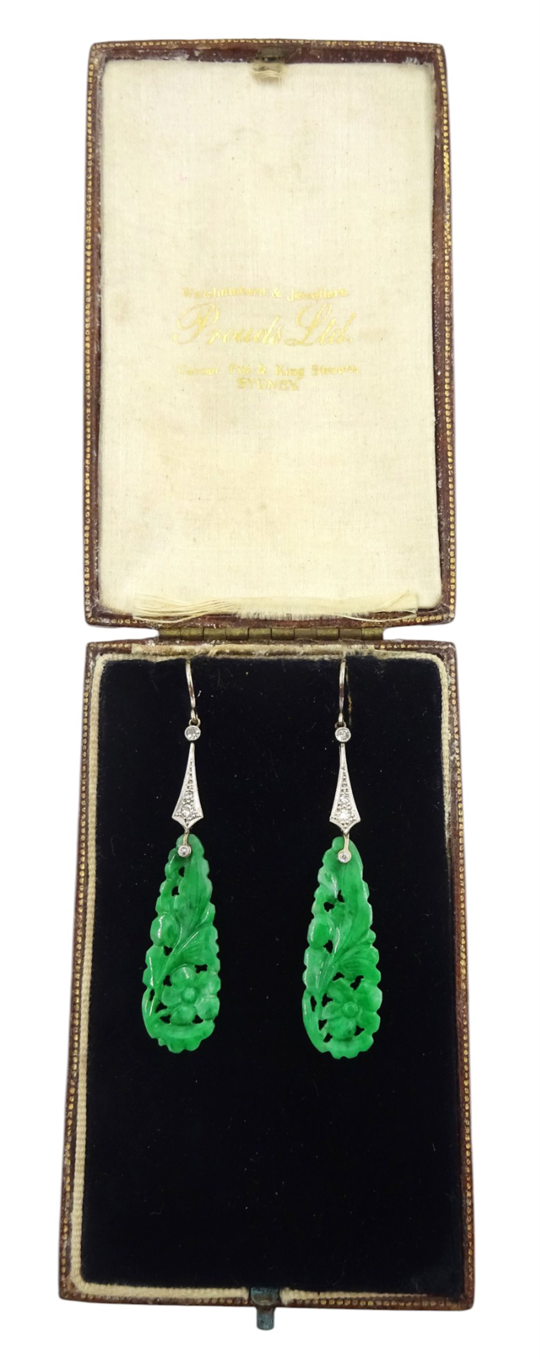 Pair of 18ct white gold Art Deco jade and diamond earrings, the pear shaped jade panels, with carved foliate decoration, suspending from milgrain set single and old cut diamond pendants, in velvet and silk lined box by Prouds Ltd, Sydney