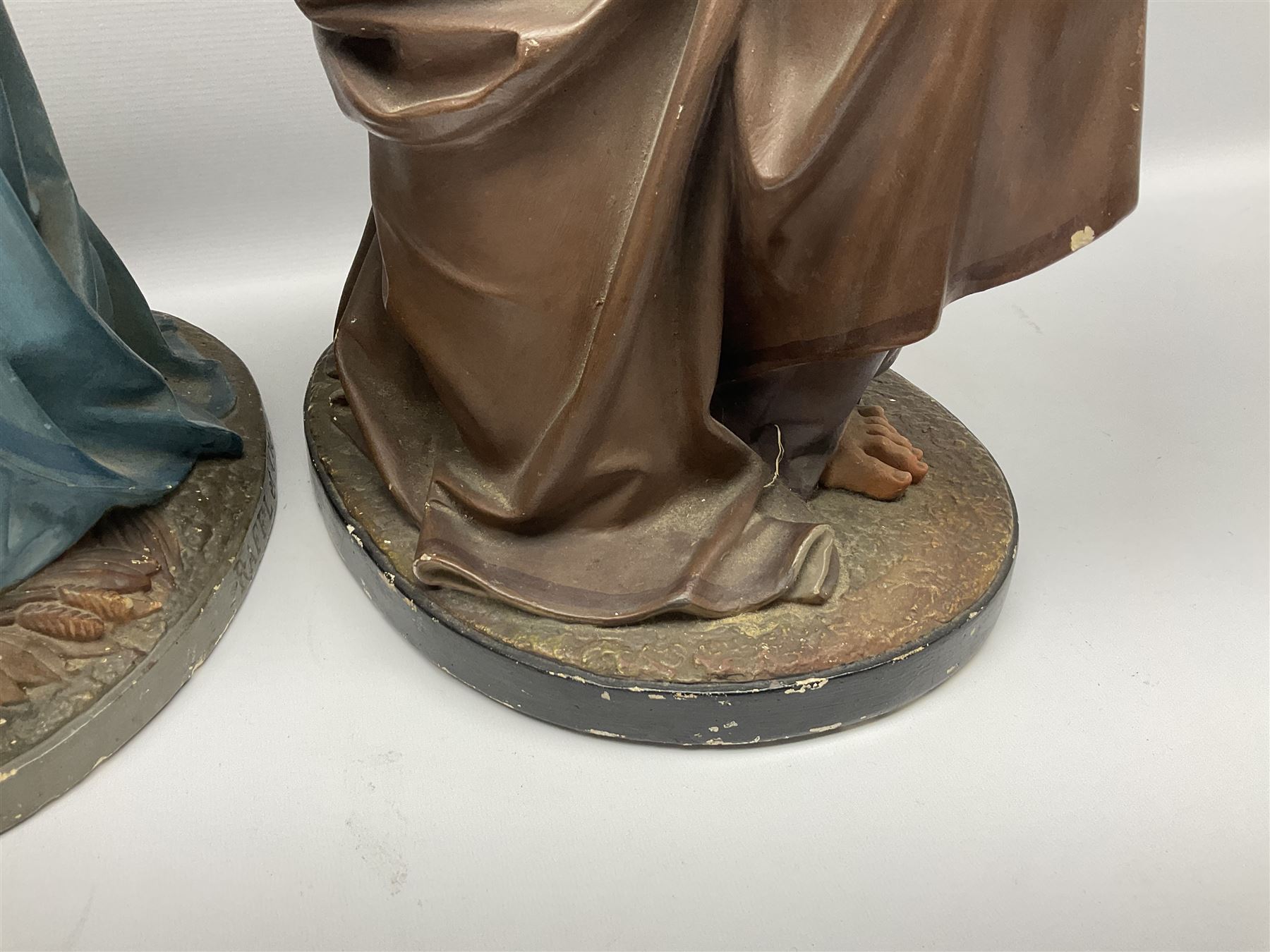Two religious painted plaster figures of Mary and Joseph kneeling on oval plinths, with impressed mark 'Raffl et Cie Paris', H60cm 