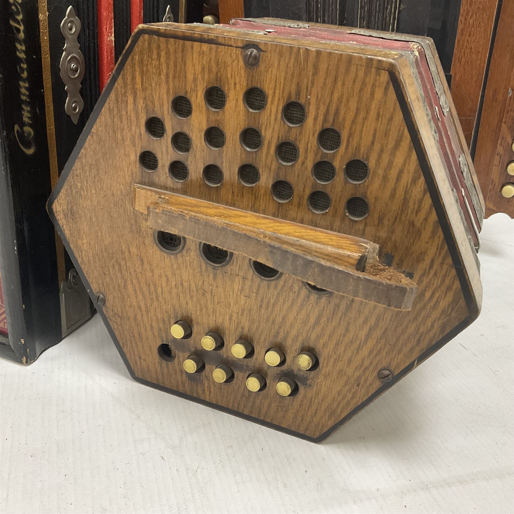 Three European concertinas, comprising Viceroy German concertina with 21 keys, hexagon wooden frame and 8 fold bellows
Oak framed concertina with 12 keys and 8 fold bellows
Commander concertina with 12 keys and 12 fold bellows
With tutor