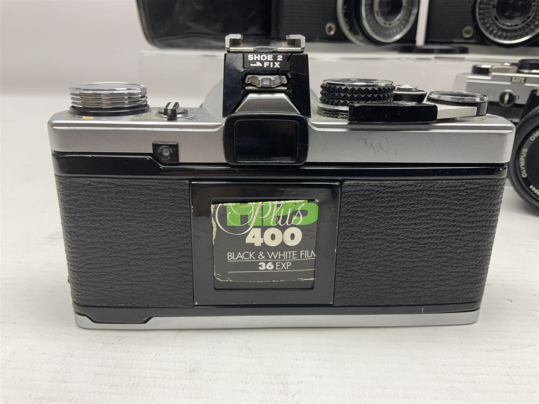 Four Olympus camera bodies, including Olympus OM10, serial no 20744269, with 'Olympus OM-System Zuiko Auto-S 50mm 1:1.8' lens serial no 3633644, Olympus OM-2 camera body serial no 460280 with 'Olympus OM-System G.Zuiko Auto-s 1:1.4 f=50mm' lens, serial no 729750, etc 