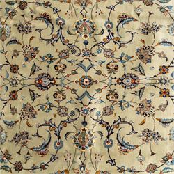 Persian Kashan rug, cream ground decorated with an all-over pattern of interlaced floral stems, rosettes and palmettes in blue, gold and rust tones, framed by layered floral borders, woven in the Kashan region of Iran