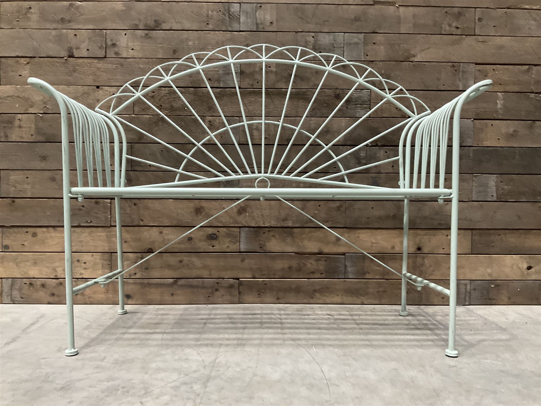 Wrought metal two seat garden bench, sunburst back, painted in pale green finish