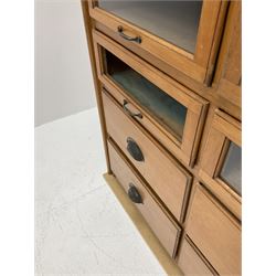 Haberdashery display cabinet with plaque ‘J.C. King Ltd, Shop fittings & Sundries, St John's Street London’, sixteen glazed front short drawers, above four deep drawers