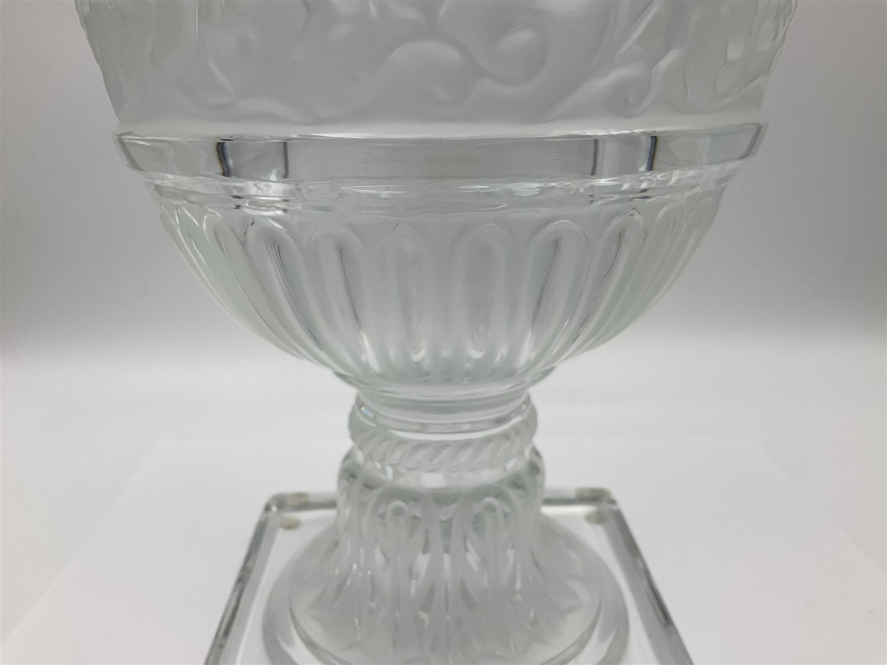 Large and impressive Lalique Versailles pattern glass vase, of classical baluster form with gadrooned flared rim, the body moulded in relief with fruiting vines above part fluting, upon a spreading circular foot with moulded decoration, and plain square plinth base, signed Lalique France to side of plinth, overall H35cm, with original box 