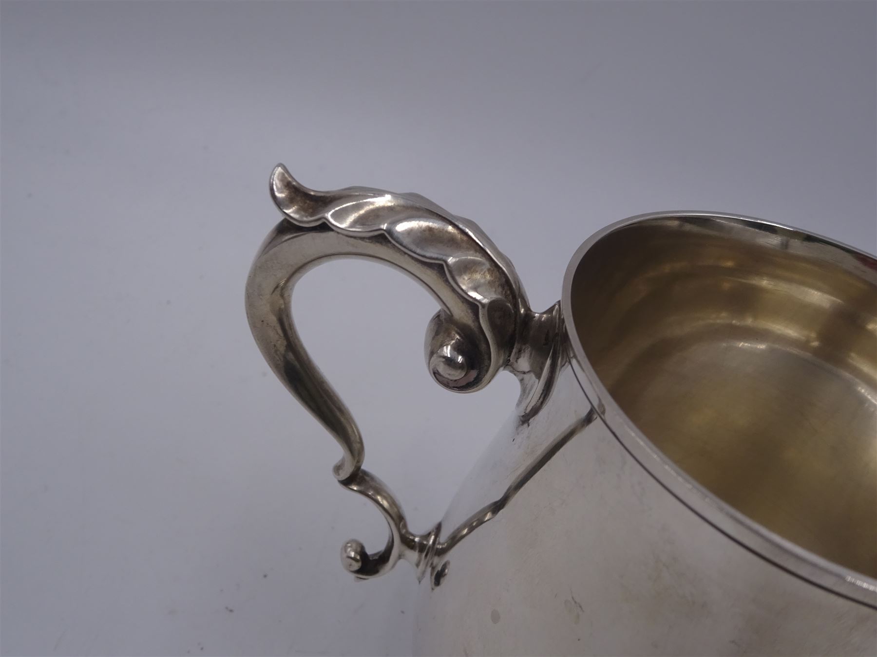 1920s silver christening mug, of plain waisted form with acanthus capped C scroll handle, upon circular stepped foot, hallmarked J B Chatterley & Sons Ltd, Birmingham 1920, H9.5cm