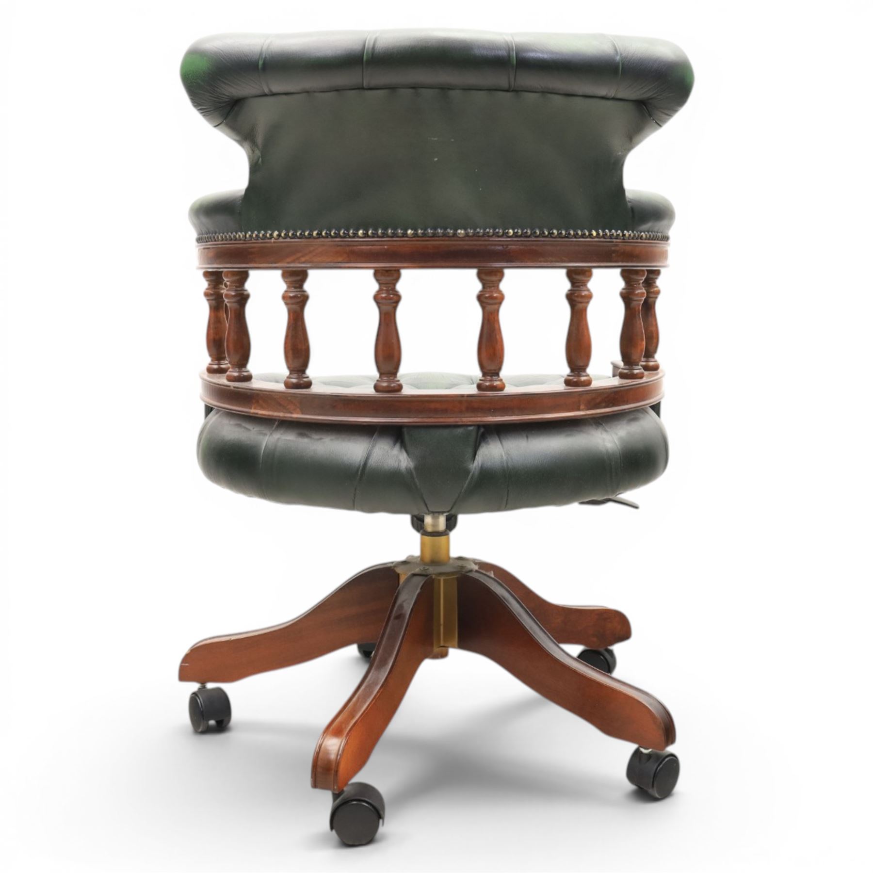 Captains swivel desk chair upholstered in buttoned green leather, five point star base raised on castors