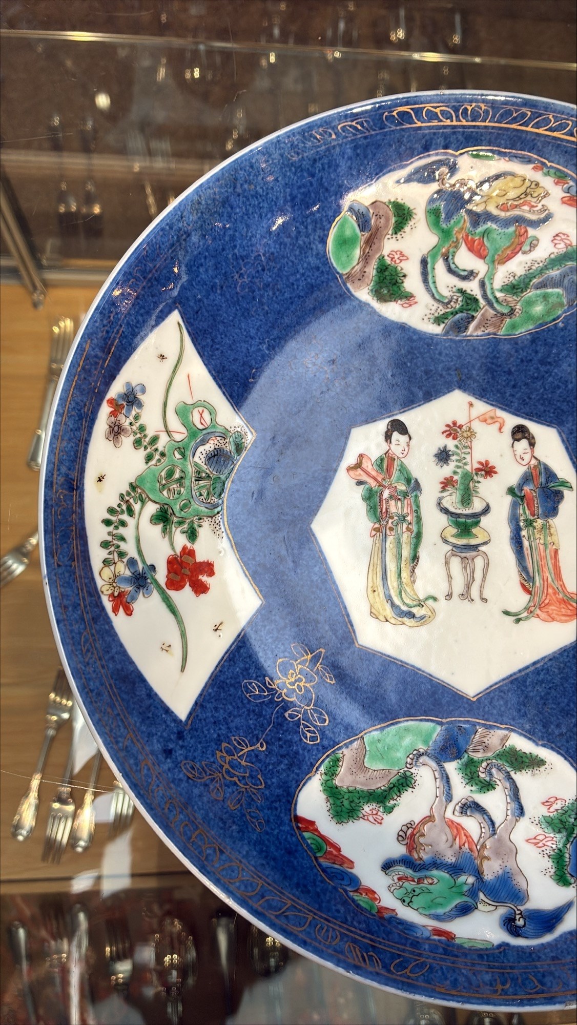 Chinese powder blue ground famille verte charger, possibly Kangxi, decorated with a central cartouche enclosing two female figures, with smaller shaped panels enclosing lions and foliage, square seal mark in blue to base, D28cm