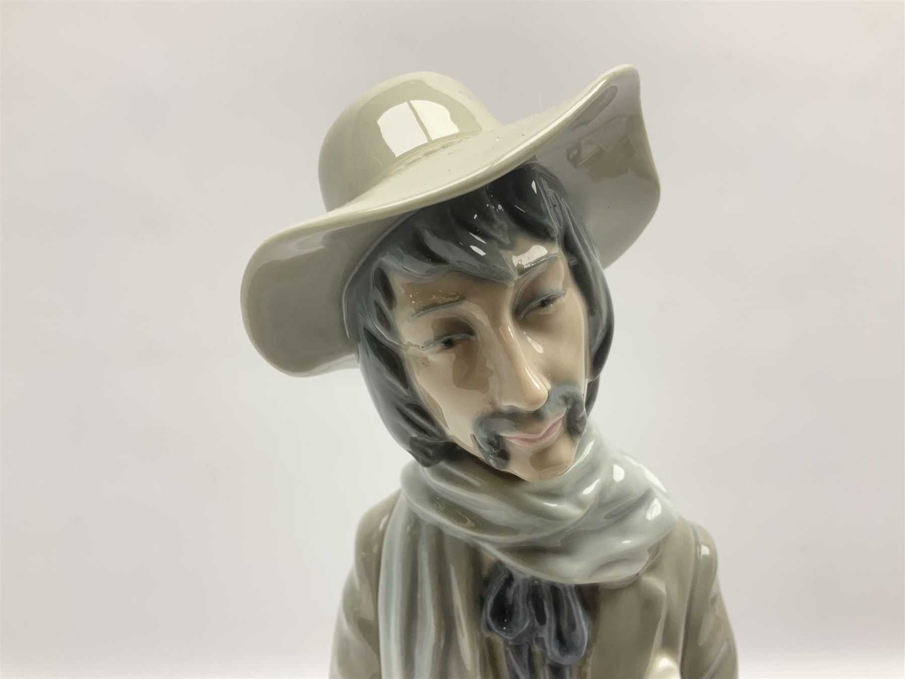 Lladro figure, Violinist, modelled as a man seated upon a  mile stone holding a violin, sculpted by Salvador Furió, no 4887,  year issued 1984, year retired 1981, H35cm