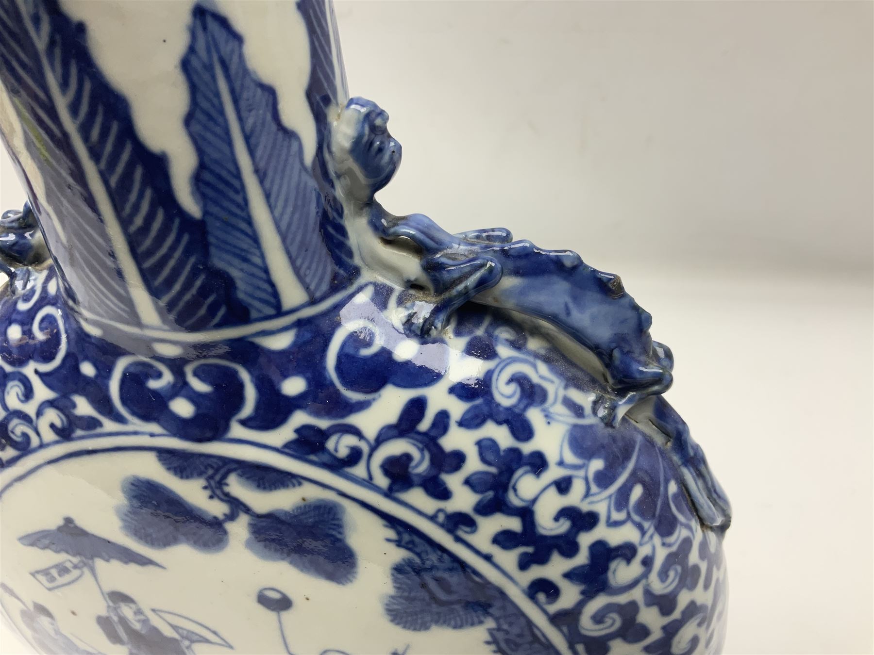 19th century Chinese blue and white moon flask vase, the central panel depicting musicians, bordered by floral, foliate and scroll decoration, with lizard handles to each shoulder, upon an oval foot, H31cm 
