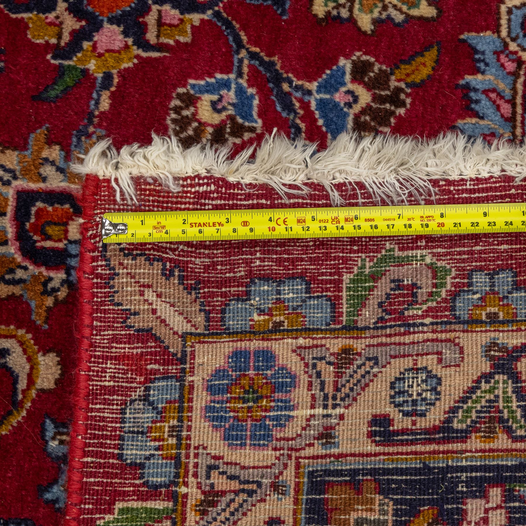 Persian Kashan wool carpet, red field centred with large floral medallion and conforming pendants, decorated with scrolling foliage and flowerheads, indigo spandrels and borders, from the region of Kashan