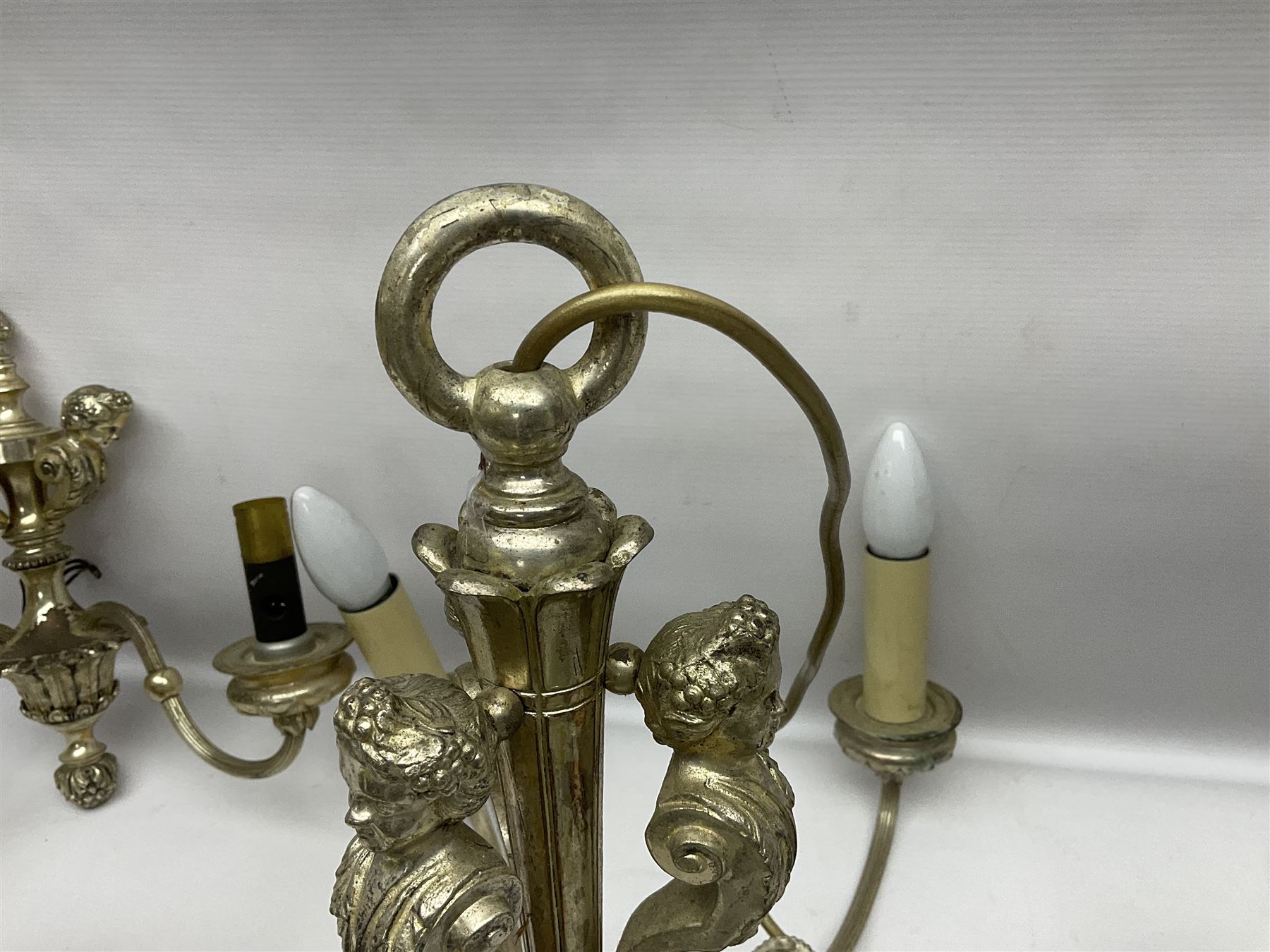 Siz branch silvered chandelier, decorated with acanthus leaves and putti, together with two matching three branch wall sconces, chandelier D65cm
